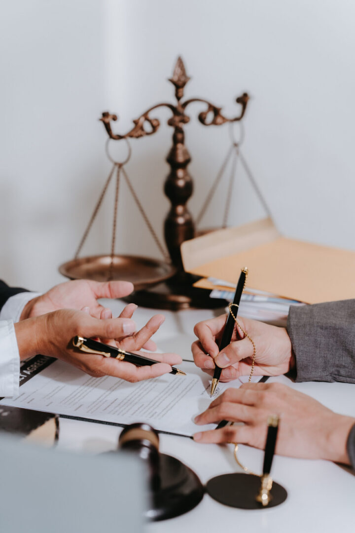 Lawyers signing legal documents with justice scales