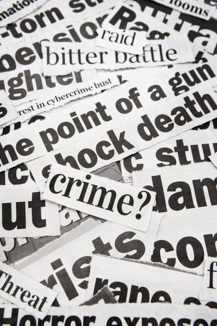 Torn newspaper headlines about crime and death