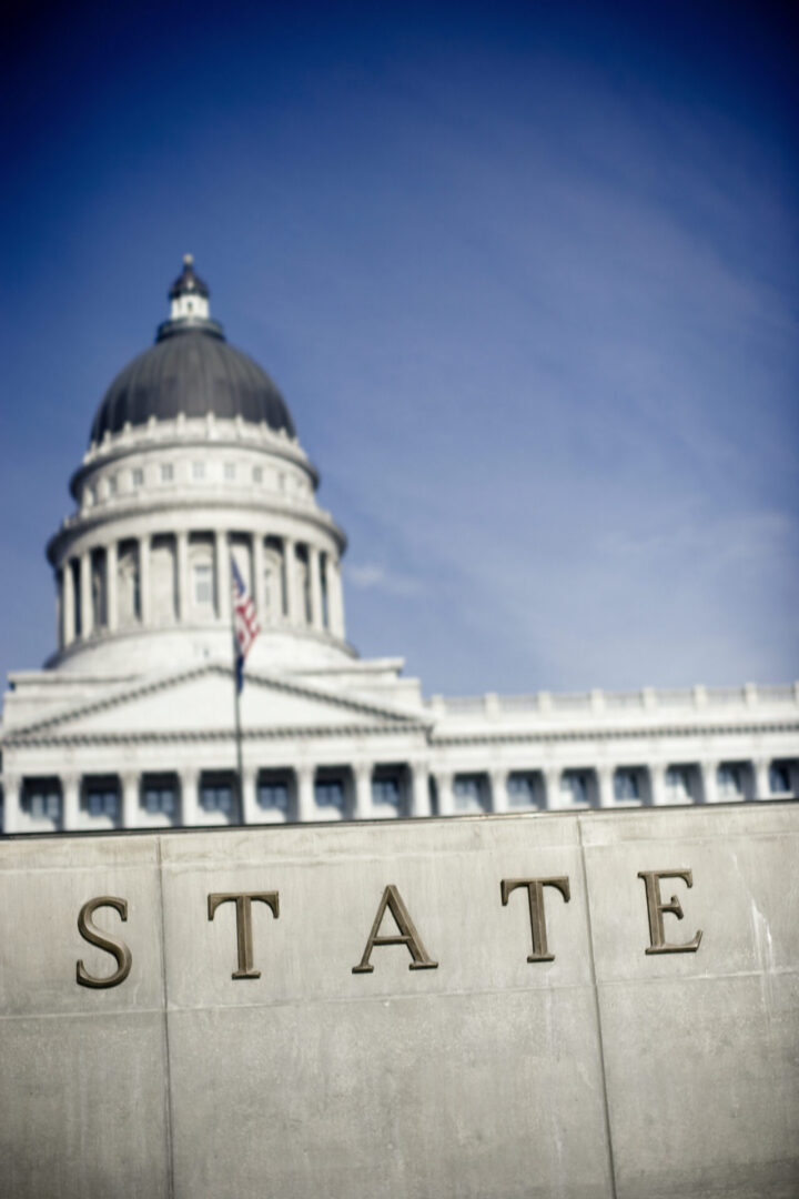 Capitol dome over wall with "STATE" letters