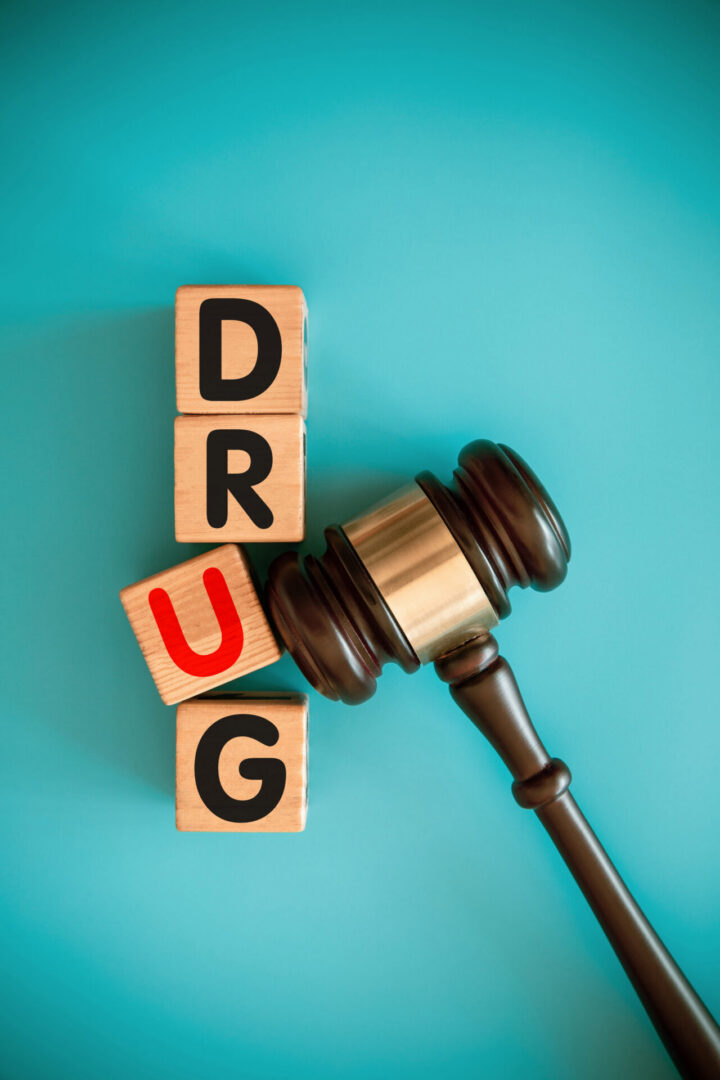 Gavel beside wooden blocks spelling DRUG
