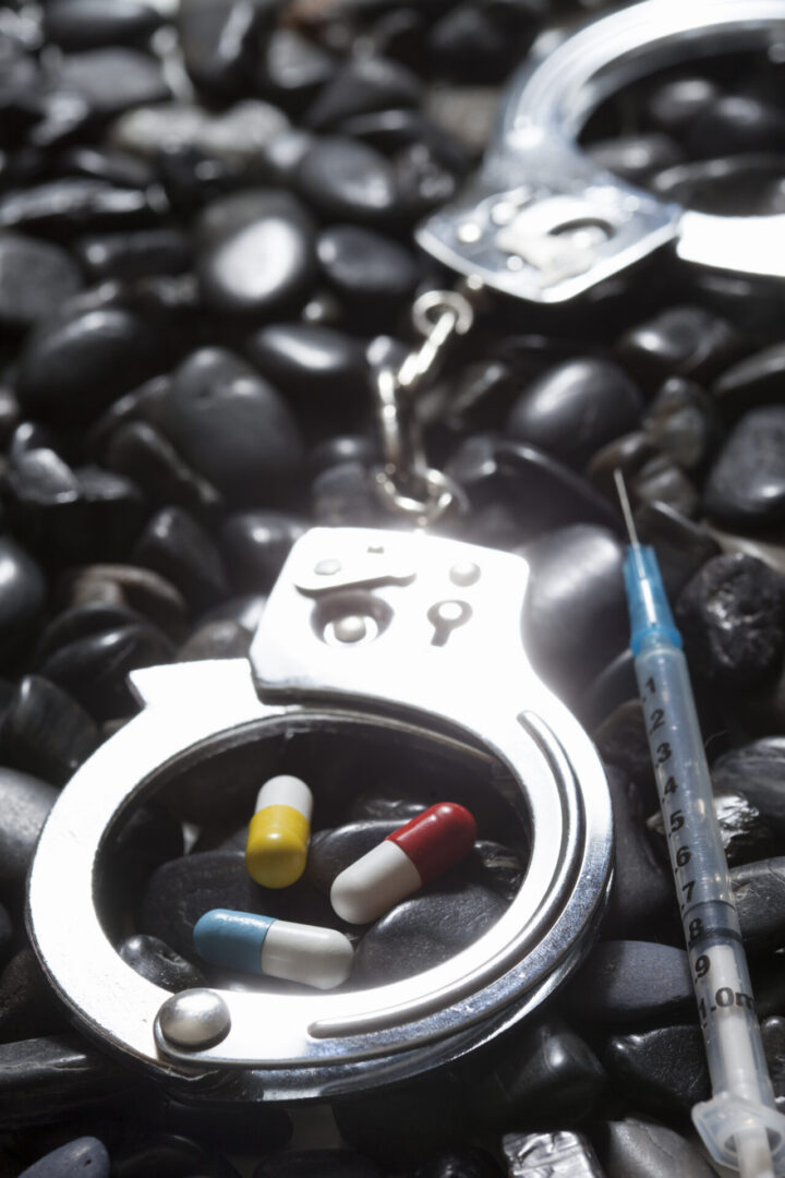 Handcuffs with pills and syringe